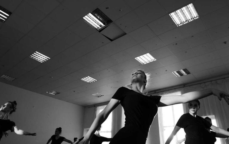 Ballerini che si esercitano in una scuola di danza, mostrando eleganza e concentrazione durante i movimenti di danza.